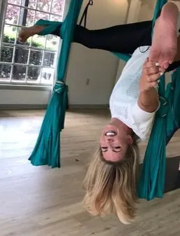 Lindsey hanging inverted in an aerial hammock