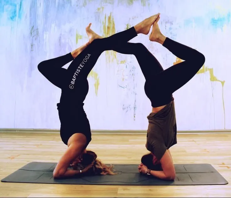 Two students holding partner headstands